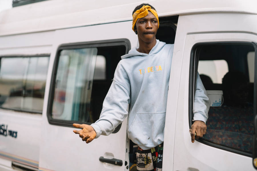 Man Exiting Van In The Bustling Streets Of Sierra Leone Wallpaper