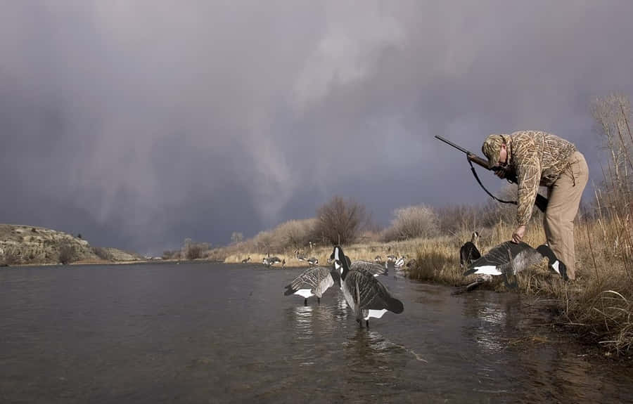 Man In Hunting Camo Petting Duck Wallpaper