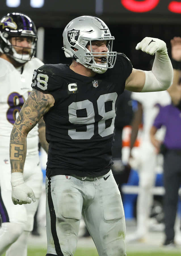 Maxx Crosby Flexing Against Baltimore Ravens Wallpaper