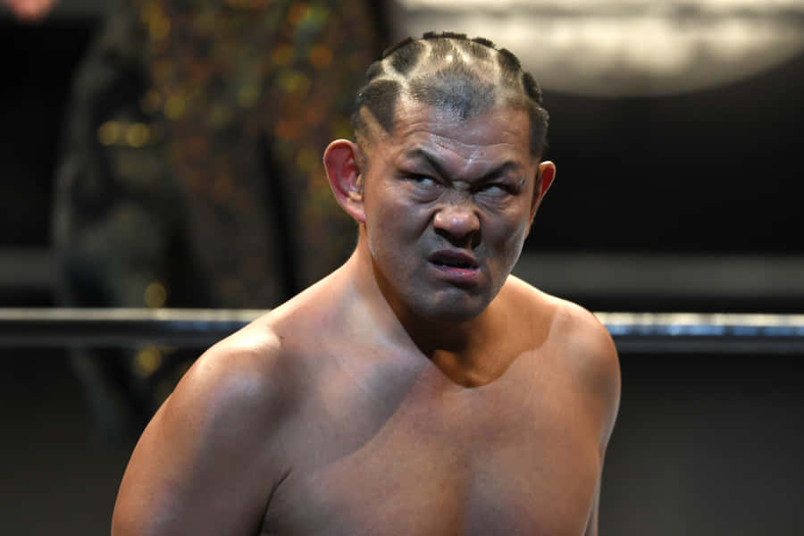 Minoru Suzuki Showcasing His Iconic Angry Expression In The Ring Wallpaper