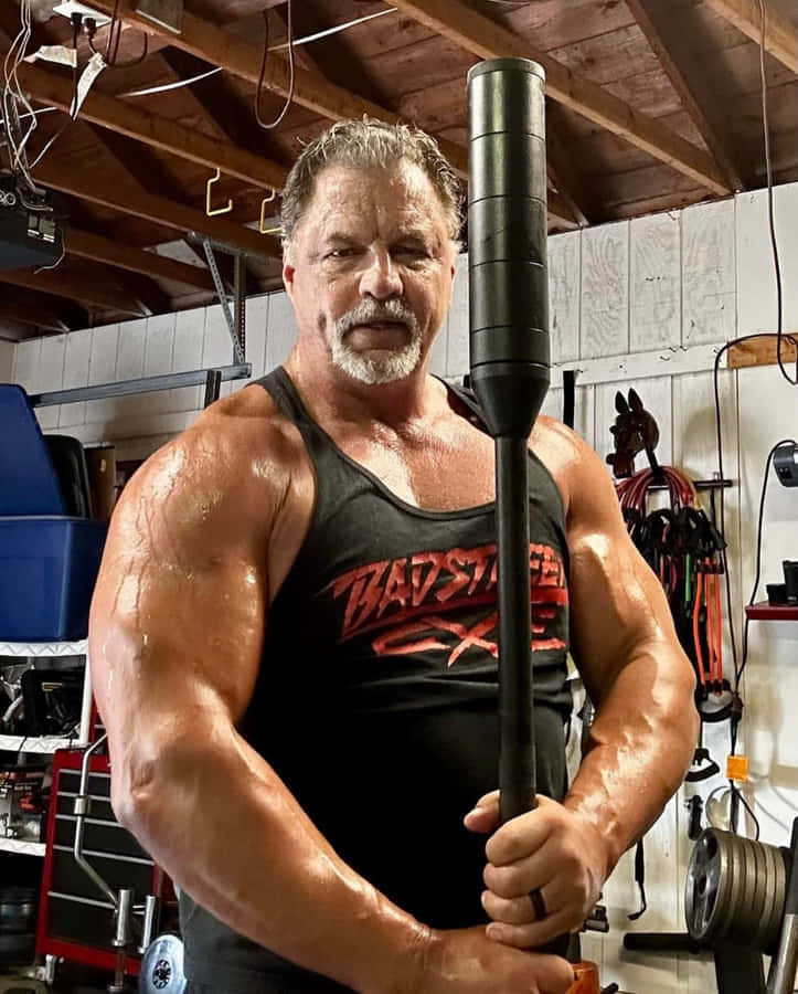 Muscled Manin Gym Holding Weighted Bar Wallpaper