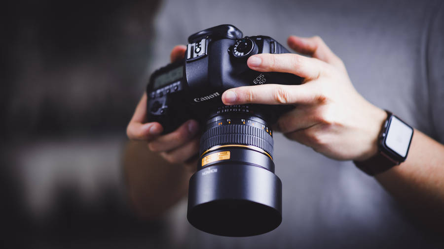 Person Holding Canon Dslr Camera Wallpaper