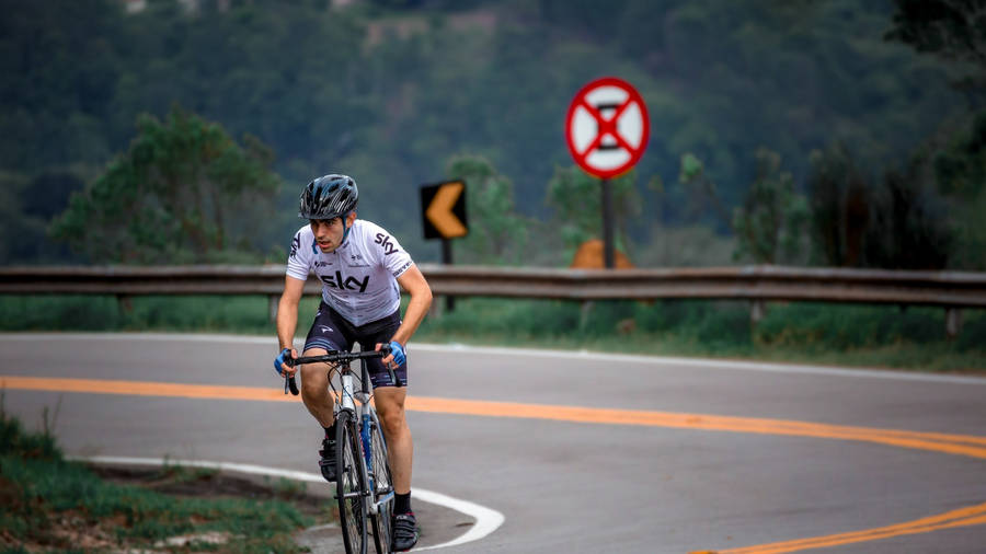 Road Bike Rider In Curvy Road Wallpaper