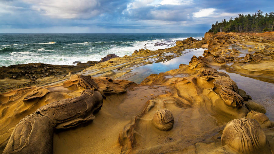 Rock Formations At A Lush Coastal Beach Wallpaper