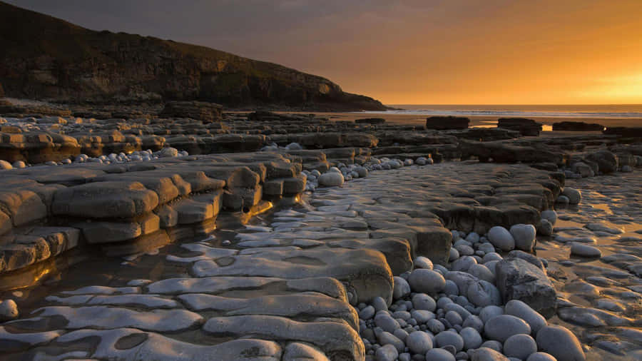 Rocks Coastal Sand Stones Sunset Wallpaper