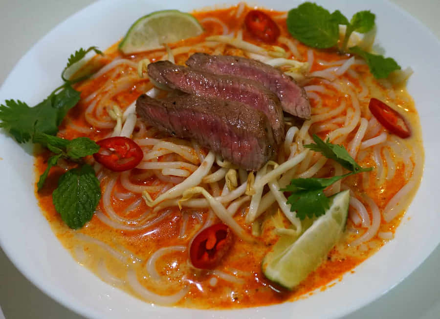 Savoring Authentic Curry Laksa With Medium-rare Beef Wallpaper