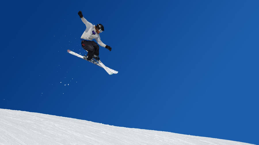 Ski Jumper Mid-air In A Majestic Winter Environment Wallpaper