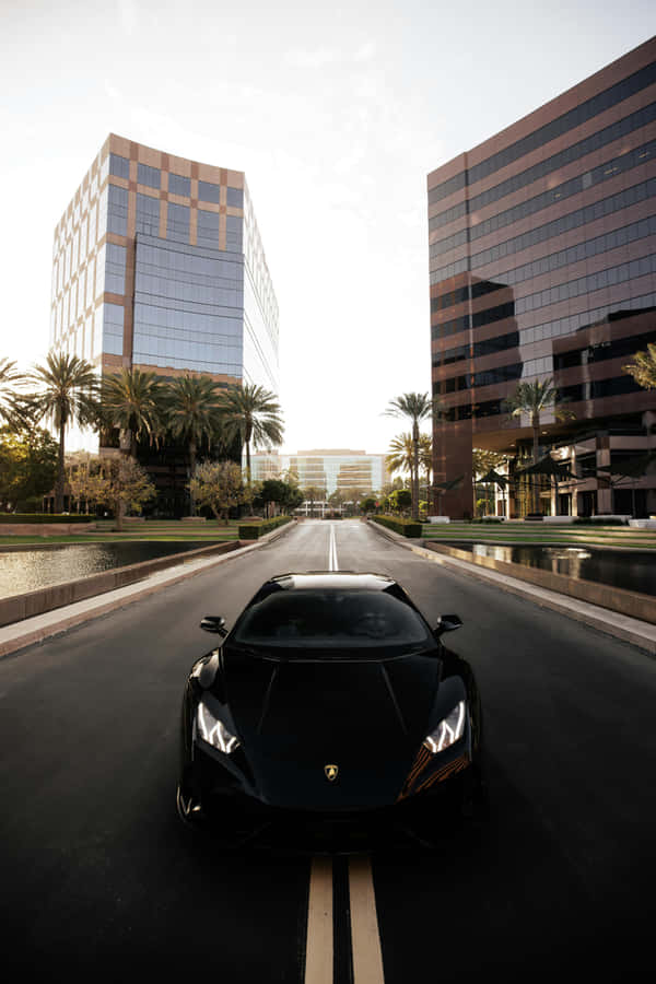 Sleek_ Black_ Sports_ Car_ Urban_ Setting.jpg Wallpaper