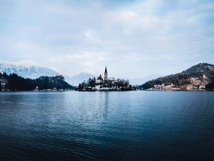Snow-kissed Julian Alps Encircling Pristine Lake Bled Wallpaper