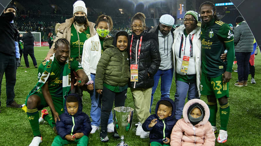 Soccer Champions Celebrationwith Familyand Trophy Wallpaper