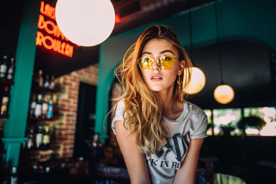 Stylish Sunglasses Reflecting The Mesmerizing Sunset Wallpaper