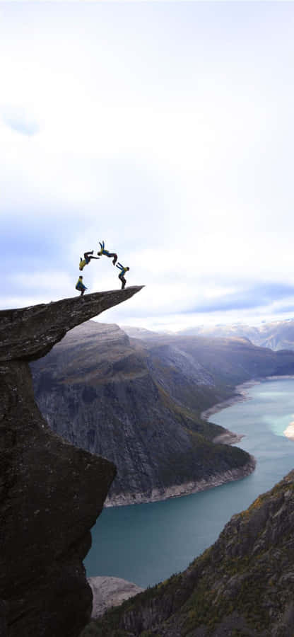 Trolltunga With Tourists Doing Backflips Wallpaper