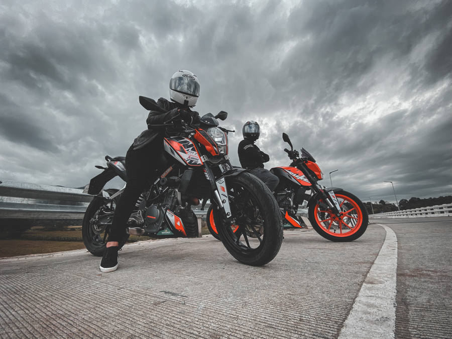 Two People Sitting On Ktm Duke 200 Wallpaper