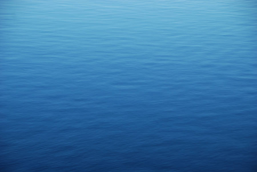 View From Above Of The Calm Blue Ocean Water Wallpaper