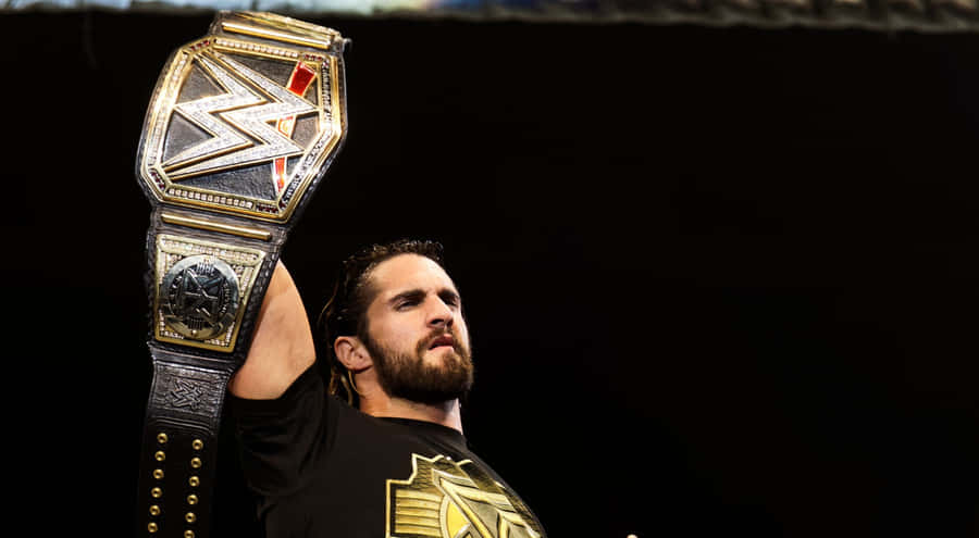 Wwe Wrestler Seth Rollins Raising His Belt Wallpaper