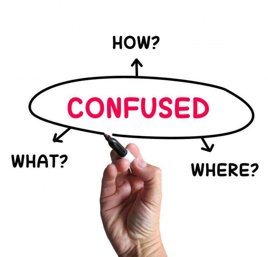 Young Man Standing At A Crossroads, Looking Lost And Confused. Wallpaper