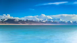 2560 X 1440 Mountain Range By The Sea Wallpaper