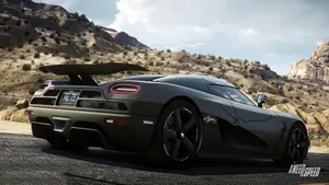 A Black Car Driving Down A Mountain Road Wallpaper