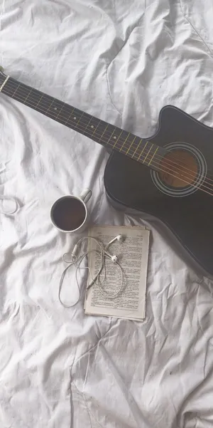 A Black Guitar Laying On Top Of A Beautiful Wooden Board. Wallpaper