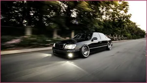 A Black Lexus Cruising Down The Road Wallpaper