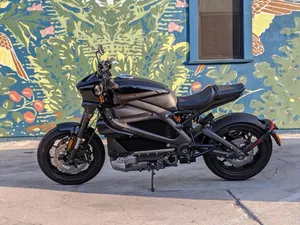 A Black Motorcycle Parked In Front Of A Colorful Mural Wallpaper