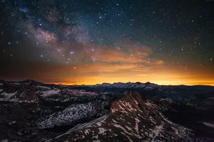 A Blanket Of Stars Above A Peaceful Orange And Pink Horizon Wallpaper