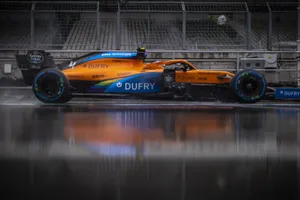 A Blue And Orange Racing Car Is Sitting On The Track Wallpaper