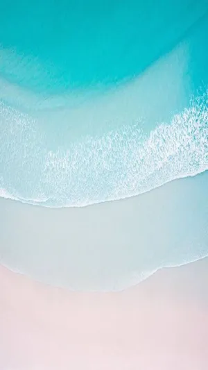 A Blue And White Beach With Waves Wallpaper