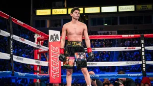 A Boxer Standing In The Ring With His Hands Raised Wallpaper