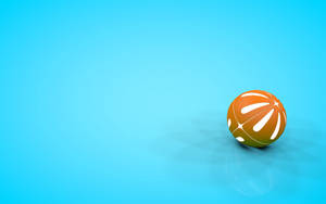 A Bright Orange Beach Ball Floating Against A Pristine Blue Sky Wallpaper