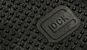 A Close Up Of A Black Leather Bag With A Logo On It Wallpaper