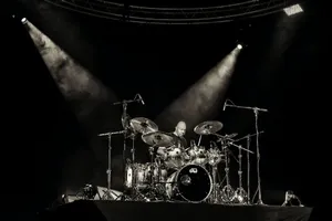 A Drummer On Stage With Spotlights Wallpaper