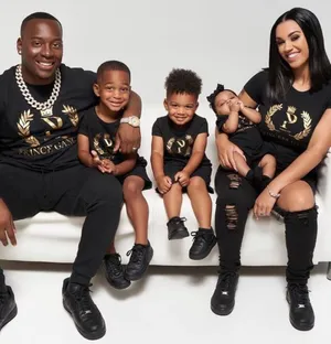 A Family Of Four Wearing Black T - Shirts Wallpaper