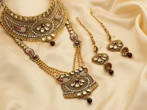 A Gold And Red Jewelry Set With A Necklace And Earrings Wallpaper