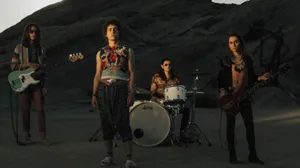 A Group Of People Standing In Front Of Rocks With Guitars Wallpaper