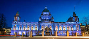 A Large Building Lit Up At Night Wallpaper