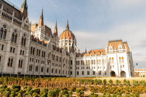 A Large Building With A Large Garden In Front Of It Wallpaper