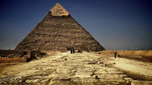 A Large Pyramid With People Walking Around It Wallpaper
