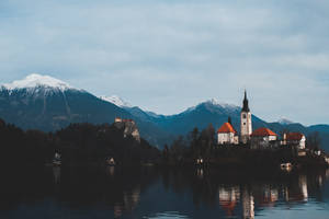 A Majestic Lake With A Castle Tower In Reflection Wallpaper