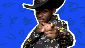 A Man In A Cowboy Hat Pointing At Something Wallpaper