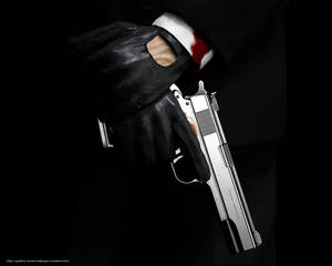 A Man In A Suit Holding A Gun Wallpaper
