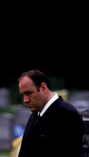 A Man In A Suit Standing In A Cemetery Wallpaper