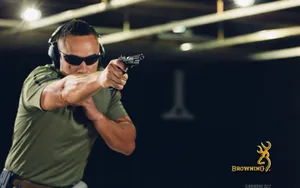 A Man In Sunglasses Is Holding A Gun Wallpaper