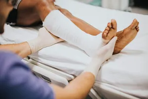 A Man Is Getting His Foot Bandaged In A Hospital Bed Wallpaper