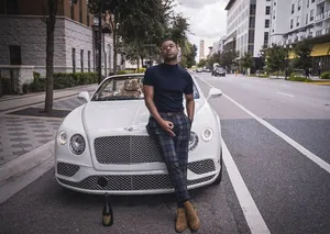A Man Is Leaning On A Bentley Continental Wallpaper