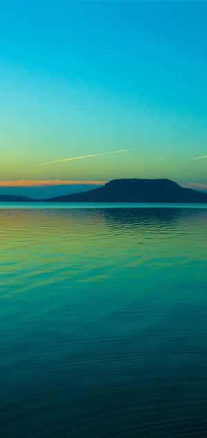 A Man Is Riding A Boat On A Lake At Sunset Wallpaper