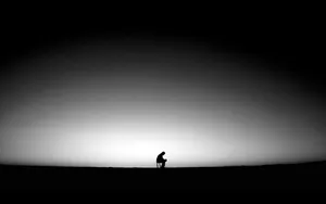 A Man Is Standing On A Hill In The Dark Wallpaper