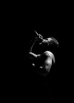 A Man Singing Into A Microphone In The Dark Wallpaper