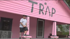 A Man Standing On The Front Porch Of A Pink House Wallpaper