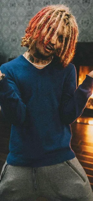 A Man With Dreadlocks Standing In Front Of A Fireplace Wallpaper